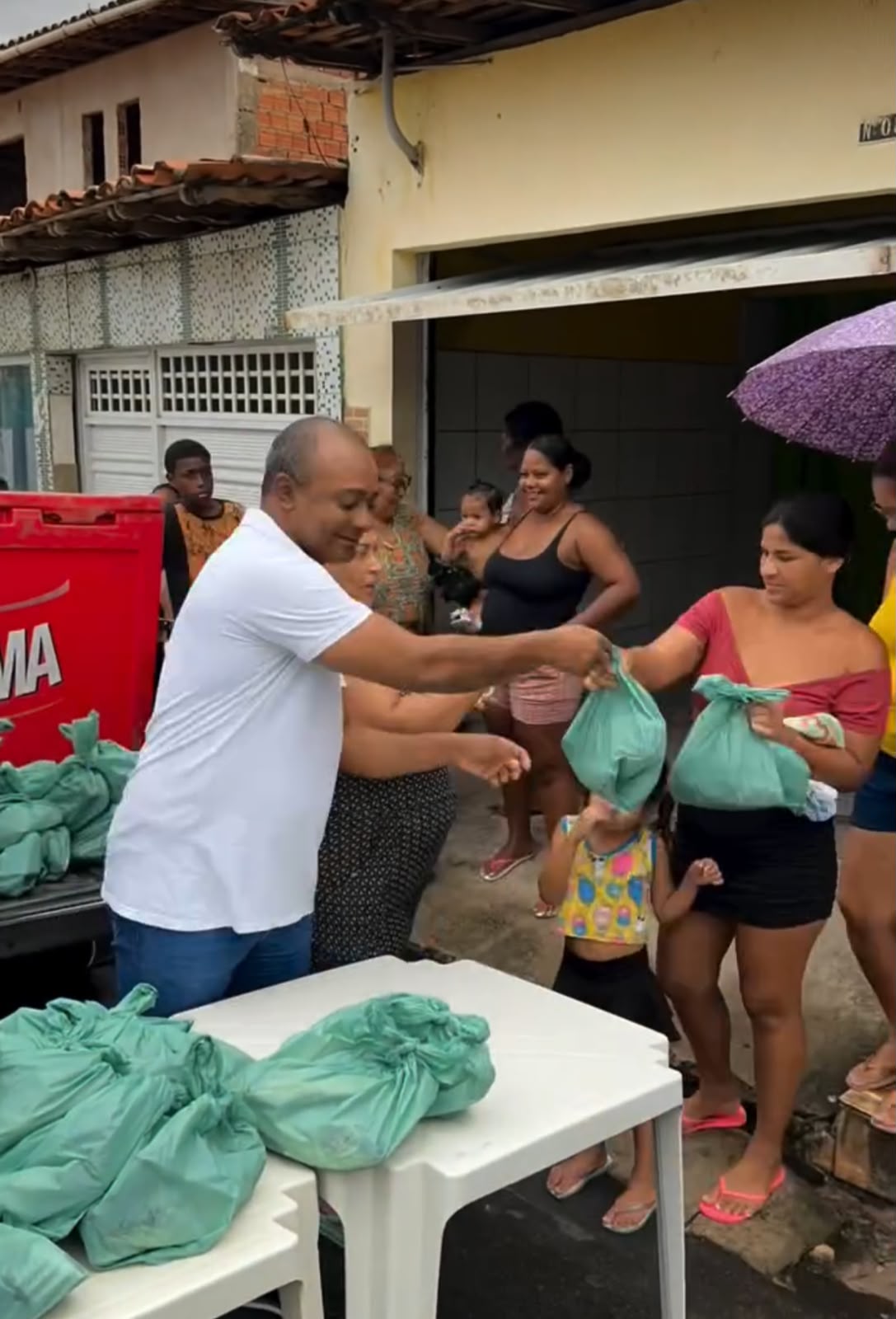 Elson entregando sacolas com alimentos para a comunidade