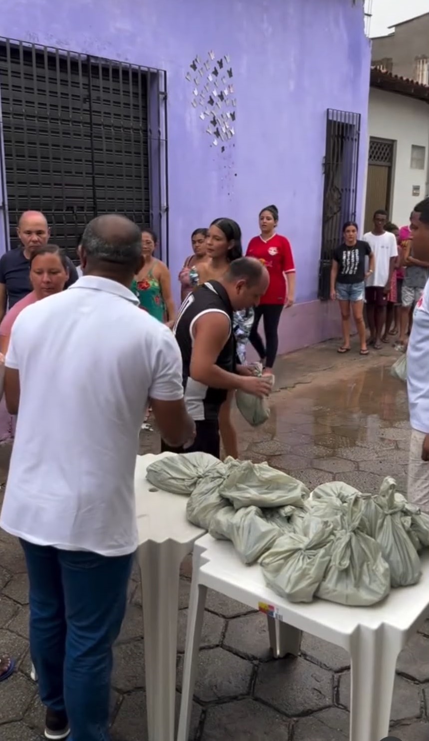 Elson entregando marmitas do Sopão Solidário para moradores
